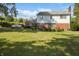 Lush backyard featuring well-maintained lawn, brick accents, white siding, and mature trees providing shade and privacy at 5363 Channing Rd, Indianapolis, IN 46226