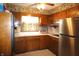 Cozy kitchen featuring ample wooden cabinetry, floral wallpaper, a stainless steel refrigerator, and bright natural light at 5363 Channing Rd, Indianapolis, IN 46226