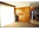 Bright living area with built-in wooden cabinets, carpeted flooring, and a view into the adjacent kitchen space at 5363 Channing Rd, Indianapolis, IN 46226