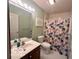 This bathroom offers a floral shower curtain, hexagon tile floor, and a wooden vanity with storage at 6036 Chinkapin Dr, Columbus, IN 47201