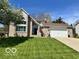 Charming two-story brick home featuring a well-manicured lawn and attached two car garage at 6036 Chinkapin Dr, Columbus, IN 47201