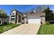 Charming two-story brick home featuring a well-manicured lawn and attached two car garage at 6036 Chinkapin Dr, Columbus, IN 47201