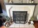 Cozy fireplace with white mantle and decorative screen, surrounded by tile at 6036 Chinkapin Dr, Columbus, IN 47201