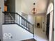 Bright foyer featuring tile flooring, black railing staircase, and an eye-catching light fixture at 6036 Chinkapin Dr, Columbus, IN 47201
