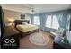 Spacious main bedroom featuring neutral walls, a ceiling fan, and a window overlooking the backyard at 6036 Chinkapin Dr, Columbus, IN 47201