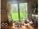 Window showcasing outdoor views, accented by decorative curtains and plants at 6036 Chinkapin Dr, Columbus, IN 47201