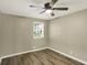 Bedroom featuring a ceiling fan, window, and light walls with wood flooring at 604 Wood St, Greenfield, IN 46140