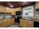 Bright kitchen features stone backsplash, wood counters and ceiling, and stainless steel appliances at 604 Wood St, Greenfield, IN 46140