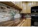 Kitchen with wood counters, light cabinets, and stacked stone backsplash at 604 Wood St, Greenfield, IN 46140