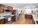 Modern kitchen with stainless steel appliances, wood cabinets, and marble countertops leading to the dining area at 6150 Red Day Rd, Martinsville, IN 46151