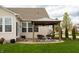 Inviting backyard patio area featuring a pergola, comfortable seating, and mature landscaping at 6717 Marble Arch Way, Indianapolis, IN 46259