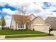 Traditional home features a well-manicured lawn, mature tree, and convenient three-car garage at 6717 Marble Arch Way, Indianapolis, IN 46259