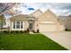 Welcoming home with tidy landscaping, attached three-car garage, and covered front entrance at 6717 Marble Arch Way, Indianapolis, IN 46259