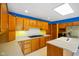 Eat-in kitchen boasts wood cabinets, tile backsplash, island with sink, and stainless steel refrigerator at 6780 E Woodland Ct, Mooresville, IN 46158