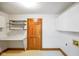 Well-lit laundry room with ample counter space, shelving and storage cabinets, with a doorway for access to other areas at 6780 E Woodland Ct, Mooresville, IN 46158