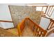 Stone wall featured on staircase with a wooden railing, adding character to the home at 6780 E Woodland Ct, Mooresville, IN 46158