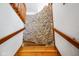 Unique staircase featuring a stone accent wall and wooden handrails at 6780 E Woodland Ct, Mooresville, IN 46158