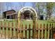 Backyard framed by vintage wooden fence and climbing trellis, showing yard and exterior of home at 701 E Main St, Westfield, IN 46074