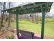 Backyard seating structure and wooden bench with green views of the lawn and mature trees at 701 E Main St, Westfield, IN 46074