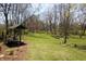 Backyard features a custom pergola seating area, flower beds and mature trees on the property at 701 E Main St, Westfield, IN 46074