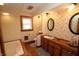 Charming bathroom with a soaking tub, wooden cabinets, and vintage floral wallpaper at 701 E Main St, Westfield, IN 46074