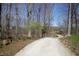 Gravel driveway winding through a wooded property under a clear sky at 701 E Main St, Westfield, IN 46074