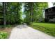 Long gravel driveway leading to a charming house surrounded by lush greenery and mature trees at 701 E Main St, Westfield, IN 46074