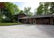 Exterior view of a well-maintained home featuring a brick facade, attached garage, and spacious gravel driveway at 701 E Main St, Westfield, IN 46074