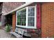 Charming exterior of a house with a brick and wood facade, bay window, and decorative red shutters at 701 E Main St, Westfield, IN 46074