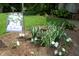 Charming flowerbed with 'Welcome' sign, colorful plants, and decorative birdhouse for a warm and inviting entry at 701 E Main St, Westfield, IN 46074