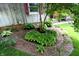 Lush landscaping with varied green plants and colorful flowers in a garden bed near a home's exterior at 701 E Main St, Westfield, IN 46074