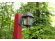 Close-up of decorative black and red light post, surrounded by lush greenery and mature trees at 701 E Main St, Westfield, IN 46074