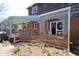 Charming brick porch with lattice railing and an outdoor seating area, nestled among lush garden beds at 701 E Main St, Westfield, IN 46074