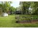 Landscaped yard featuring terraced flower beds, mature trees, and plenty of open space for recreation at 701 E Main St, Westfield, IN 46074