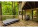 Spacious back deck with a hot tub and wooden deck furniture, leading to a forest at 7249 Tuliptree Trl, Indianapolis, IN 46256