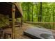 Wooden deck with a hot tub, railing, and view of the surrounding forest at 7249 Tuliptree Trl, Indianapolis, IN 46256