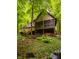 A view of the back exterior of the home surrounded by mature trees and lush green ground cover at 7249 Tuliptree Trl, Indianapolis, IN 46256