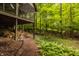 Exterior view of the house with stacked firewood, the forest and stairs to the deck at 7249 Tuliptree Trl, Indianapolis, IN 46256