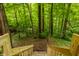 Wooden stairs lead to a verdant backyard, blending natural beauty with outdoor living at 7249 Tuliptree Trl, Indianapolis, IN 46256