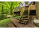 Home exterior with multilevel decks and stairs nestled in a wooded, sloped yard at 7249 Tuliptree Trl, Indianapolis, IN 46256