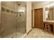 Bathroom with a glass enclosed shower and vanity area with decorative wall and floor tile at 7249 Tuliptree Trl, Indianapolis, IN 46256