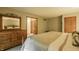 Bedroom with a large dresser, matching mirror, and comfortable bedding with a neutral color scheme at 7249 Tuliptree Trl, Indianapolis, IN 46256
