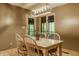 Cozy dining area with a light fixture, windows with greenery view, wooden table, and matching wooden chairs at 7249 Tuliptree Trl, Indianapolis, IN 46256