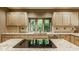 Bright kitchen features light wood cabinets, granite countertops, tile backsplash, and a large window overlooking greenery at 7249 Tuliptree Trl, Indianapolis, IN 46256