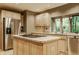 Modern kitchen featuring stainless steel appliances, central island with cooktop, and light wood cabinets at 7249 Tuliptree Trl, Indianapolis, IN 46256