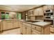 Beautiful kitchen with stainless appliances, large island cooktop, wooden cabinets, hardwood floors, and bright breakfast nook at 7249 Tuliptree Trl, Indianapolis, IN 46256