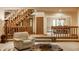 Open-concept living area with staircase, hardwood floors, and a view into the dining room at 7249 Tuliptree Trl, Indianapolis, IN 46256