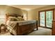 Comfortable bedroom with a wrought iron bed frame, a bedside table, and access to a private outdoor patio at 7249 Tuliptree Trl, Indianapolis, IN 46256
