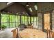 Relaxing sunroom with vaulted ceiling, wooden furniture and views of the surrounding forest at 7249 Tuliptree Trl, Indianapolis, IN 46256