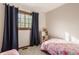 Bright bedroom with a pink floral comforter, dark blue curtains, and natural lighting at 757 Howe Dr, Carmel, IN 46032